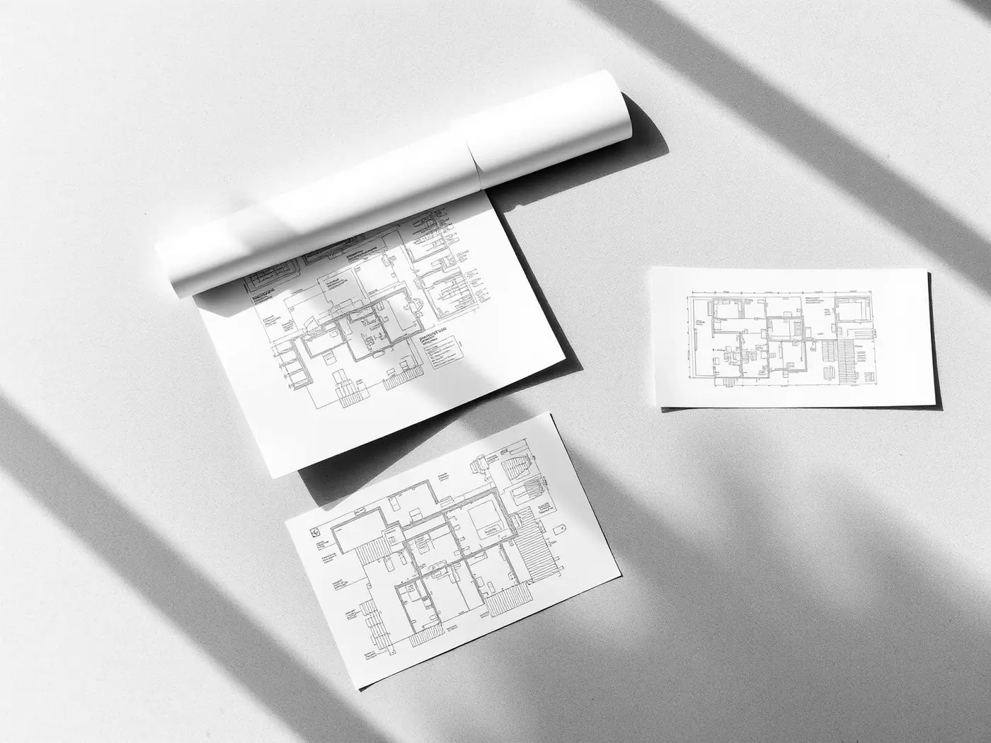 Architectural blueprints arranged on a light surface, representing audit documentation